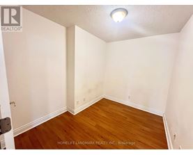A room with wooden flooring and white walls.