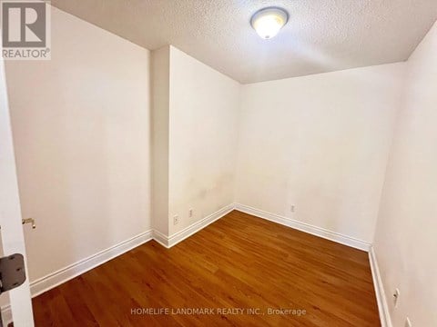 A room with wooden flooring and white walls.