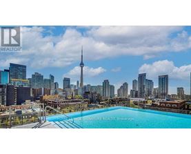 A pool on a balcony with a city skyline in the background.