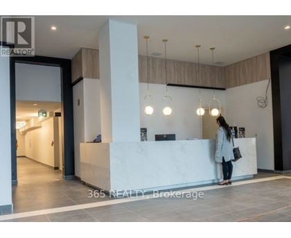 A woman stands at the front desk of a realty office.
