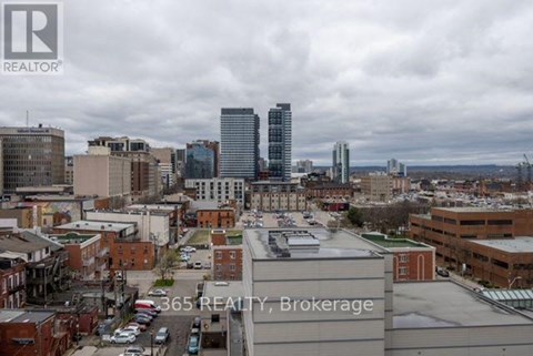 A real estate sign is displayed on a building in a city.