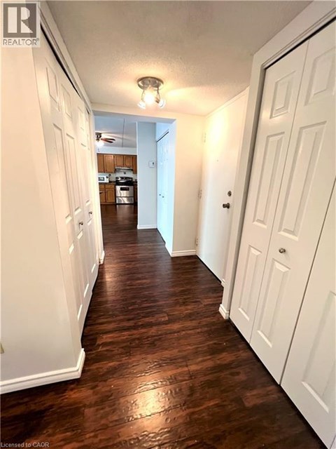 A long hallway with white doors on both sides and a light on the ceiling.