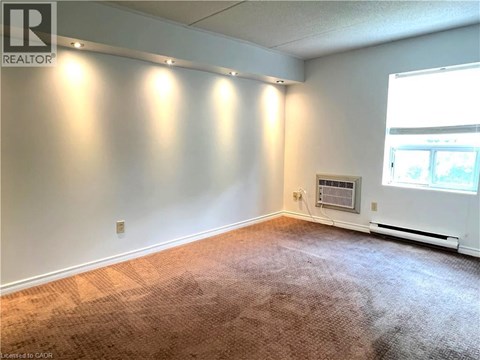 A room with a carpeted floor and a window.