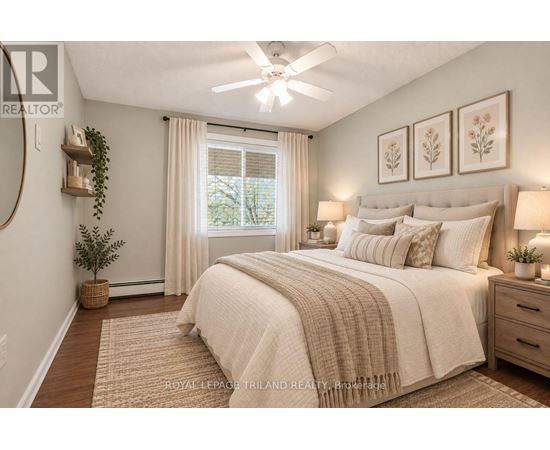 A bedroom with a large bed, a ceiling fan, and a window with curtains.