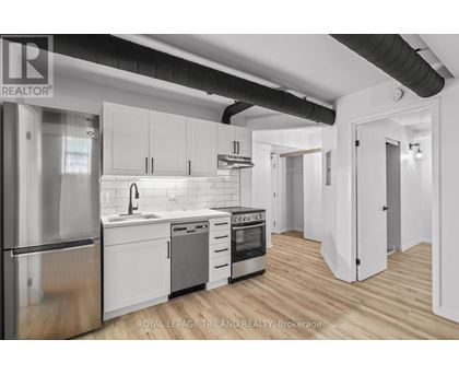 A modern kitchen with white cabinets and stainless steel appliances.