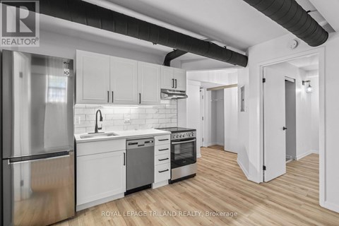 A modern kitchen with white cabinets and stainless steel appliances.