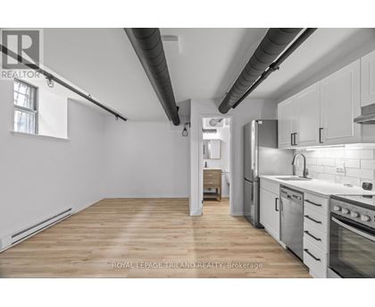 A kitchen with white cabinets and a wooden floor.