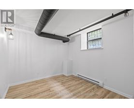 A white room with wooden floors and a window.