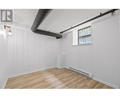 A white room with wooden floors and a window.