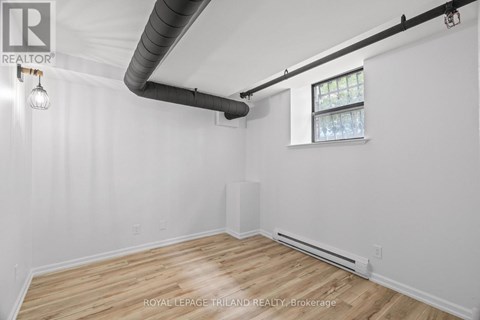 A white room with wooden floors and a window.