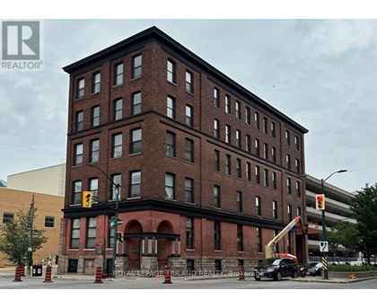 A large red brick building with a crane in front of it.