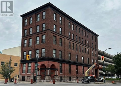 A large red brick building with a crane in front of it.