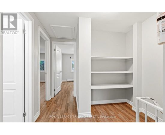 A white room with a wooden floor and a white door.