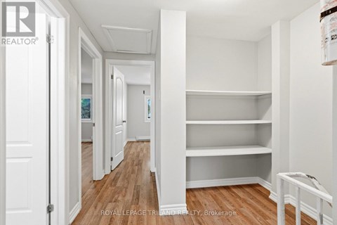 A white room with a wooden floor and a white door.