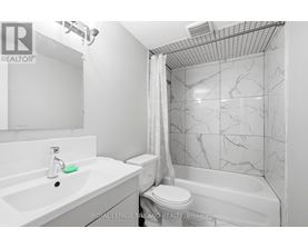 A white bathroom with a marble tile shower.