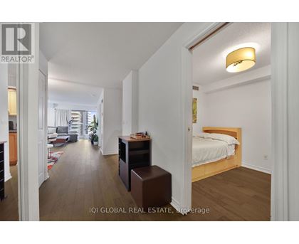 A bedroom with a bed, nightstand, and a dresser with a mirror.