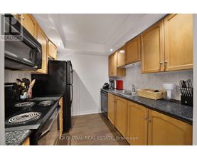 A kitchen with wooden cabinets and black appliances.