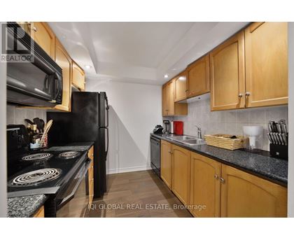 A kitchen with wooden cabinets and black appliances.