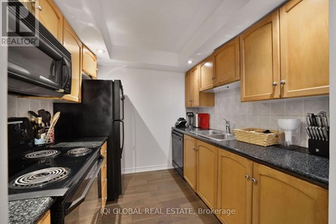 A kitchen with wooden cabinets and black appliances.