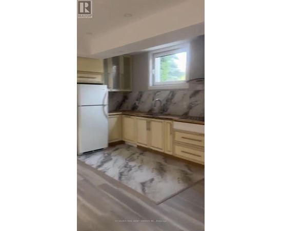 A kitchen with a white refrigerator and marble flooring.