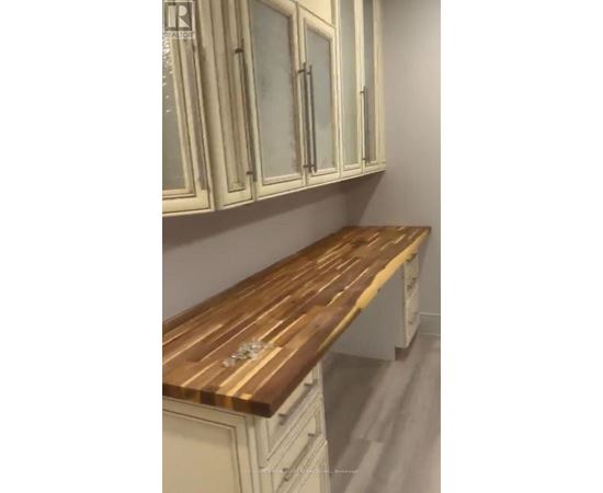 A kitchen with white cabinets and a wooden countertop.