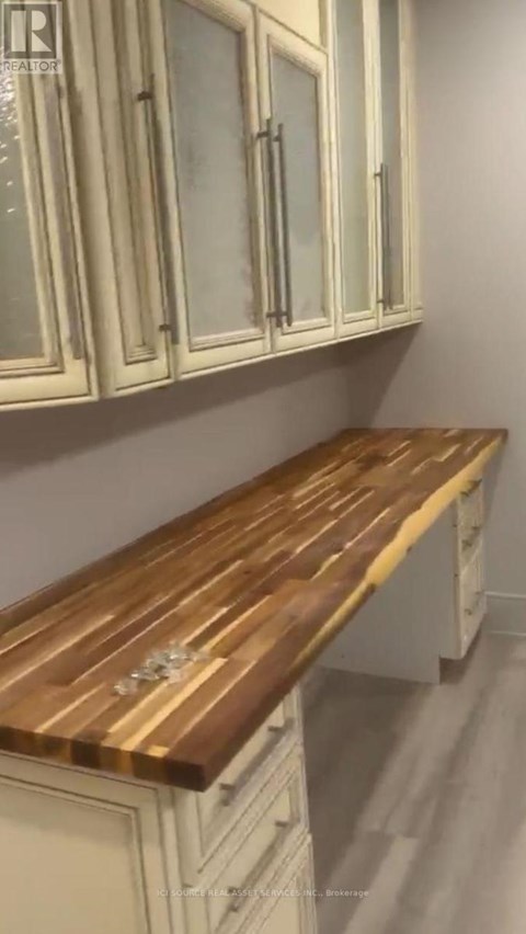 A kitchen with white cabinets and a wooden countertop.