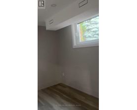 A room with a window and a wooden floor.
