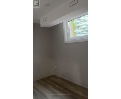 A room with a window and a wooden floor.