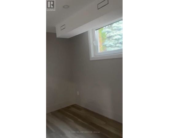 A room with a window and a wooden floor.