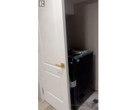 A white door is open to a small dark room.