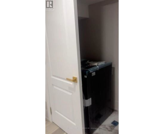 A white door is open to a small dark room.