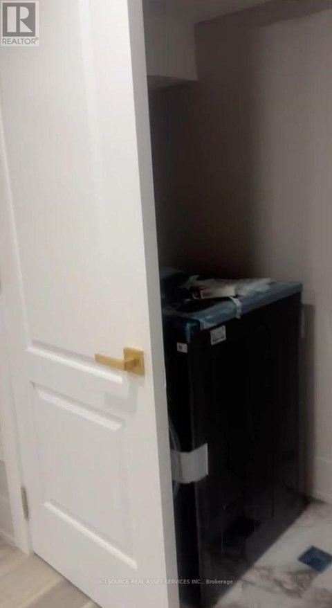 A white door is open to a small dark room.