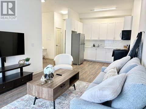A living room with a white couch and a wooden coffee table.