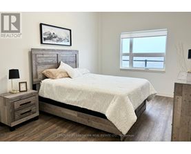 A bedroom with a large bed and a wooden nightstand.
