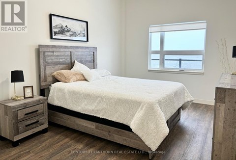 A bedroom with a large bed and a wooden nightstand.