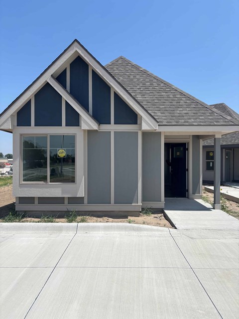 A modern house with a grey and white exterior and a black door.