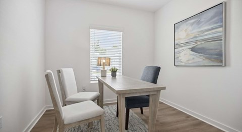 A dining room with a table, chairs and a painting on the wall.