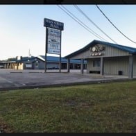 A sign for a car dealership is in front of a building.