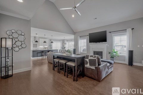 A spacious living room with a large couch and a television mounted on the wall.