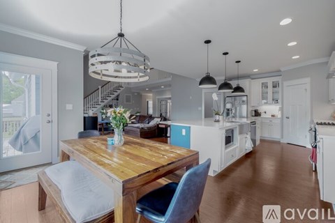 A modern kitchen with a wooden dining table and chairs.