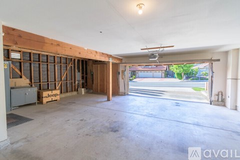 A spacious garage with a Jeep on a wooden pallet.