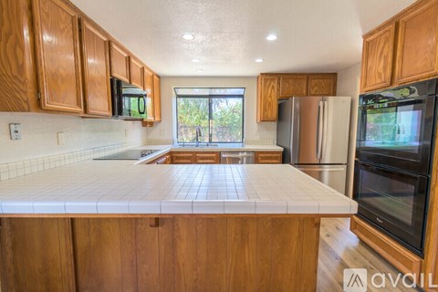 A kitchen with wooden cabinets and a white countertop.