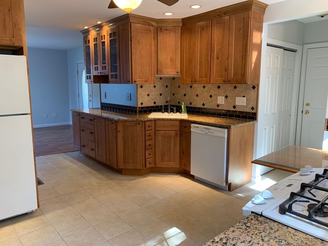 A kitchen with wooden cabinets and a white refrigerator.
