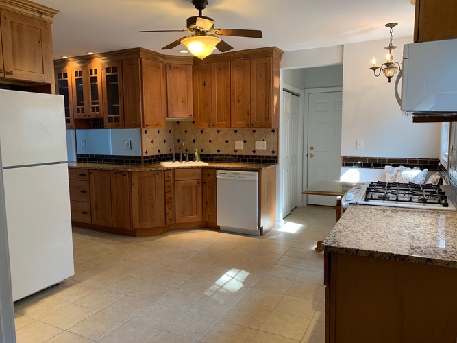 A kitchen with wooden cabinets and a white refrigerator.