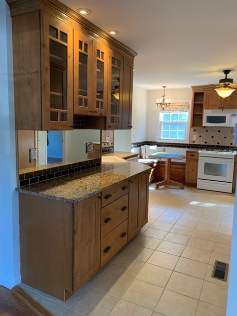 A kitchen with wooden cabinets and a granite countertop.