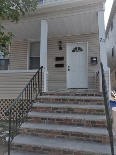 A house with a white door and a black railing.