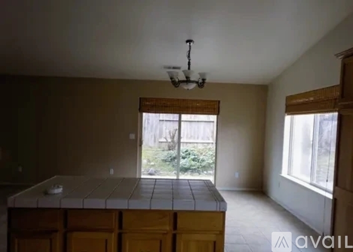 A room with a large table and a window overlooking a garden.