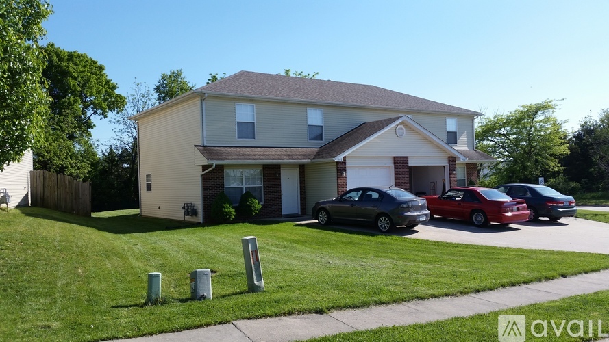 A house with a red car parked in front.