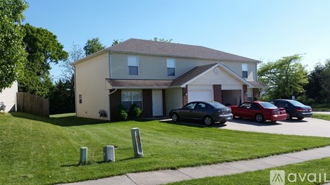 A house with a red car parked in front.