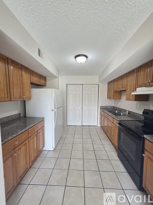 A kitchen with wooden cabinets and a black oven.
